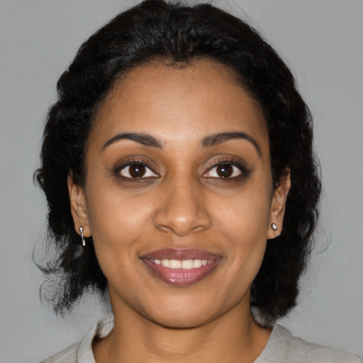 Joyful black young-adult female with medium  black hair and brown eyes