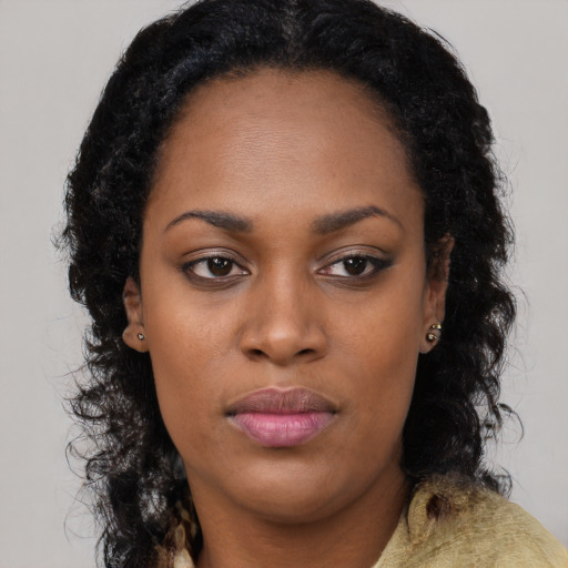 Joyful black young-adult female with long  brown hair and brown eyes