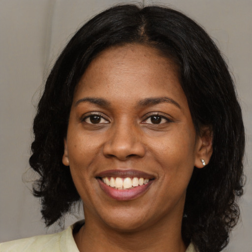 Joyful black young-adult female with medium  brown hair and brown eyes