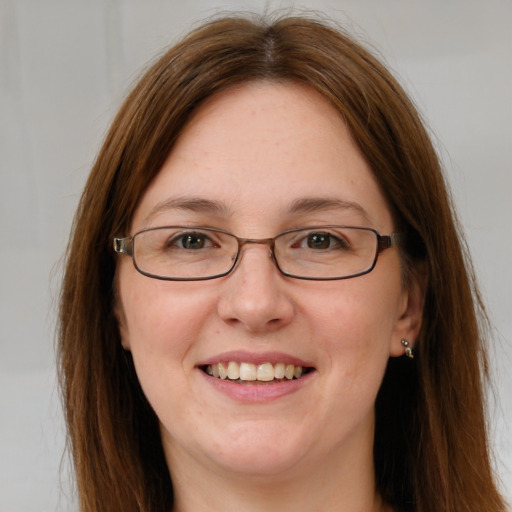 Joyful white adult female with long  brown hair and blue eyes