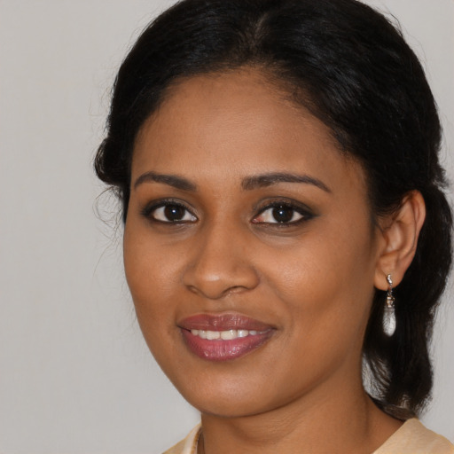 Joyful black young-adult female with medium  brown hair and brown eyes