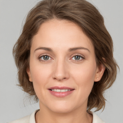 Joyful white young-adult female with medium  brown hair and grey eyes