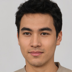 Joyful asian young-adult male with short  black hair and brown eyes