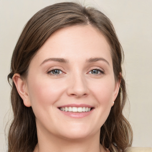 Joyful white young-adult female with medium  brown hair and grey eyes