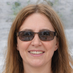 Joyful white young-adult female with long  brown hair and blue eyes