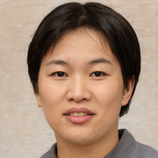 Joyful asian young-adult female with short  brown hair and brown eyes