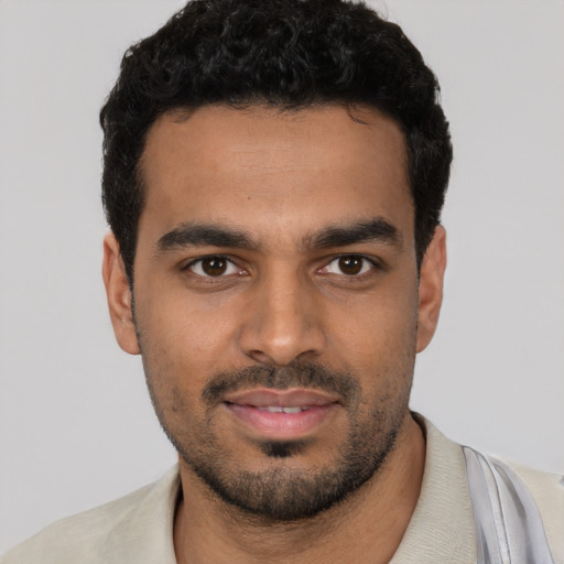 Joyful latino young-adult male with short  black hair and brown eyes