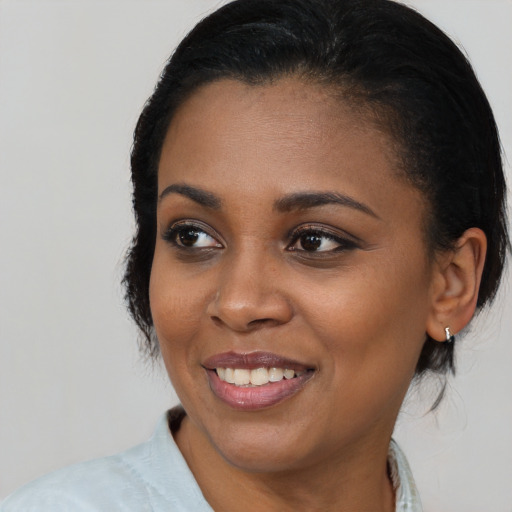Joyful black young-adult female with medium  black hair and brown eyes