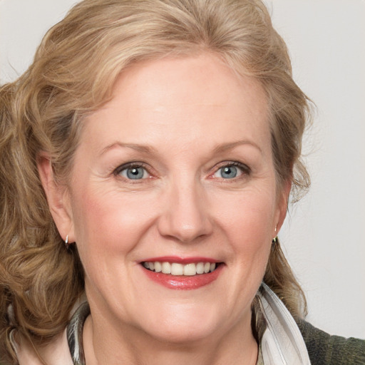 Joyful white adult female with medium  brown hair and blue eyes