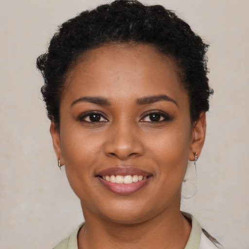 Joyful black young-adult female with short  brown hair and brown eyes