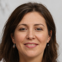 Joyful white adult female with long  brown hair and grey eyes