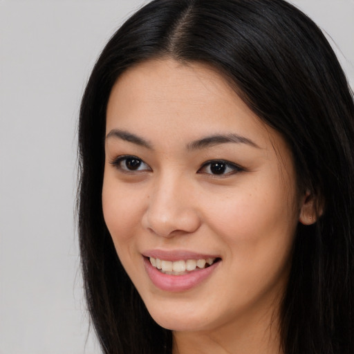 Joyful asian young-adult female with long  brown hair and brown eyes