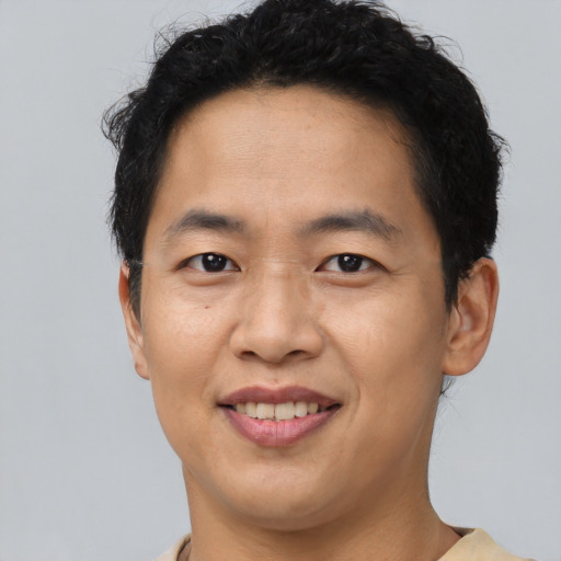 Joyful asian young-adult male with short  black hair and brown eyes