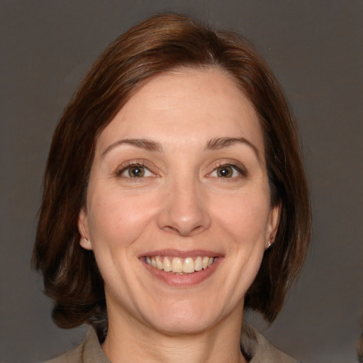 Joyful white adult female with medium  brown hair and brown eyes