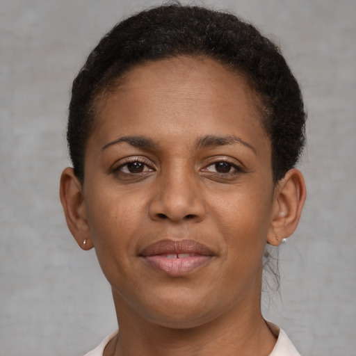 Joyful black young-adult female with short  brown hair and brown eyes