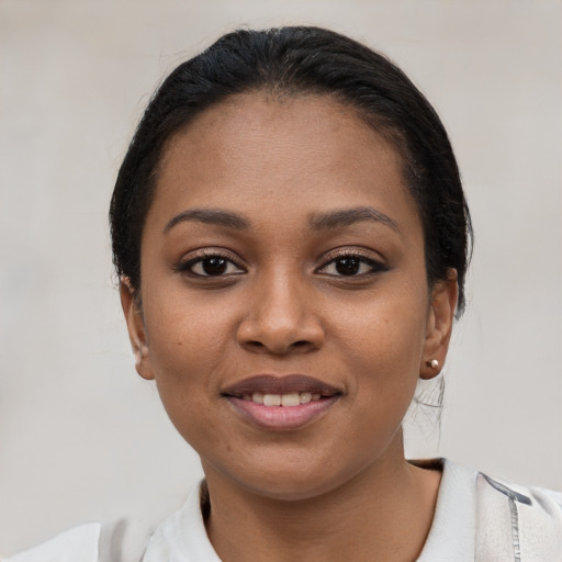 Joyful black young-adult female with short  black hair and brown eyes