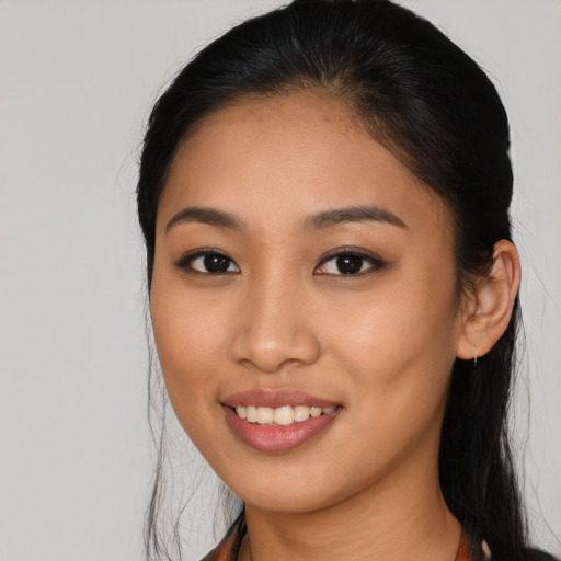 Joyful latino young-adult female with long  brown hair and brown eyes