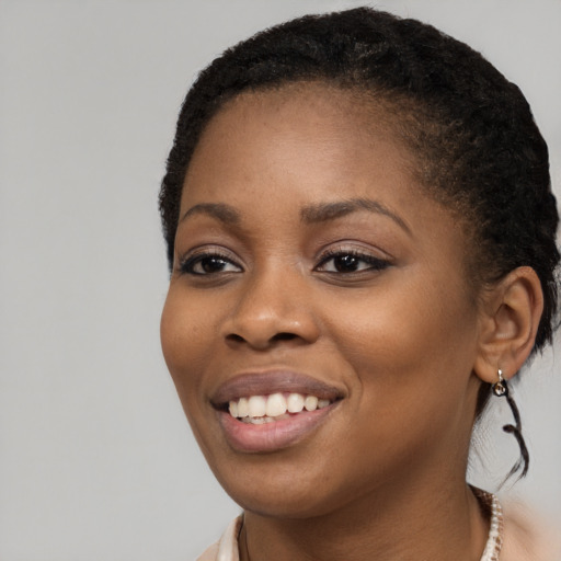 Joyful black young-adult female with long  brown hair and brown eyes