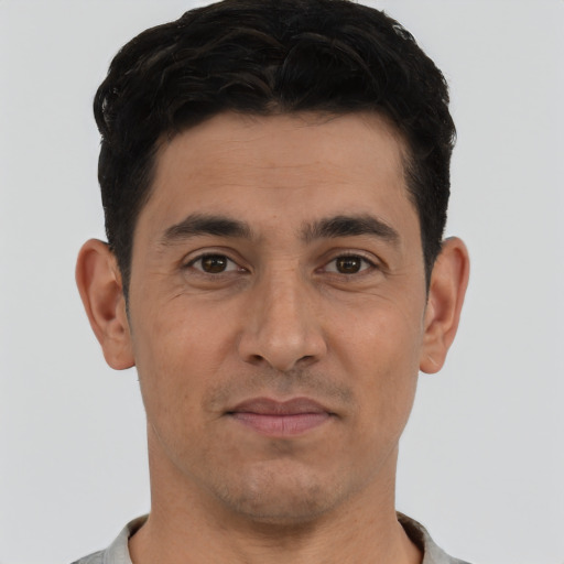 Joyful white young-adult male with short  black hair and brown eyes
