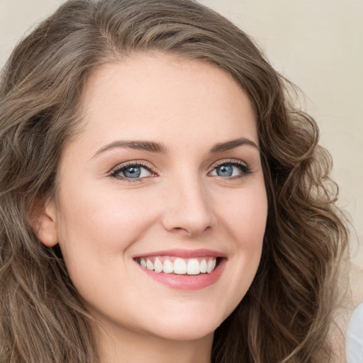 Joyful white young-adult female with long  brown hair and green eyes