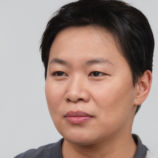 Joyful asian young-adult female with short  brown hair and brown eyes