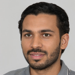 Joyful latino young-adult male with short  black hair and brown eyes