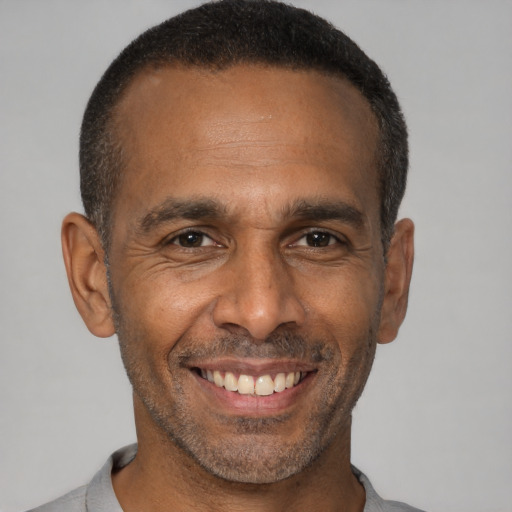 Joyful latino adult male with short  black hair and brown eyes