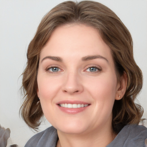 Joyful white young-adult female with medium  brown hair and blue eyes