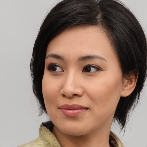 Joyful asian young-adult female with medium  brown hair and brown eyes