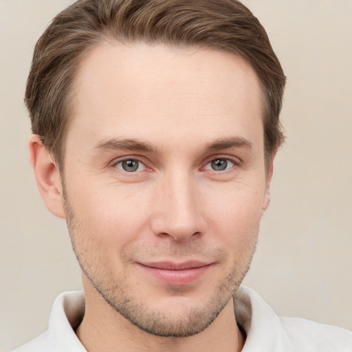 Joyful white young-adult male with short  brown hair and grey eyes