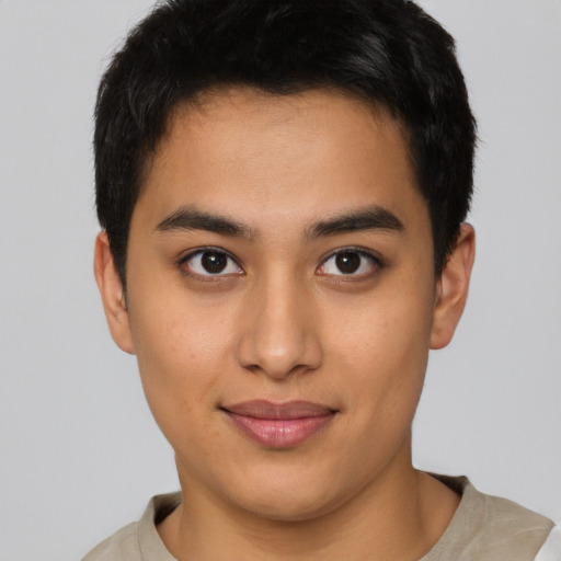 Joyful latino young-adult male with short  brown hair and brown eyes