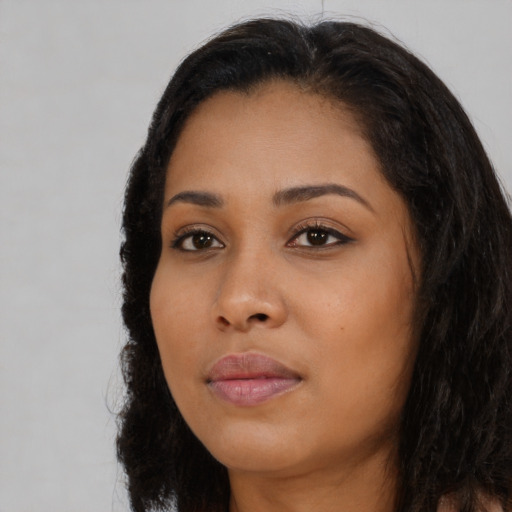 Joyful black young-adult female with long  black hair and brown eyes