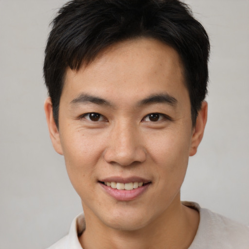 Joyful asian young-adult male with short  brown hair and brown eyes