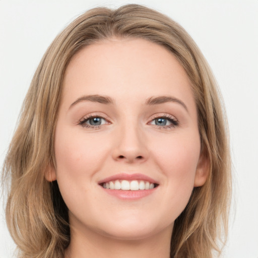 Joyful white young-adult female with long  brown hair and blue eyes