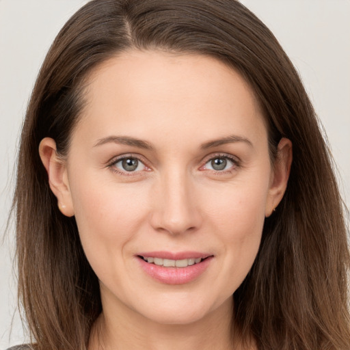 Joyful white young-adult female with long  brown hair and brown eyes