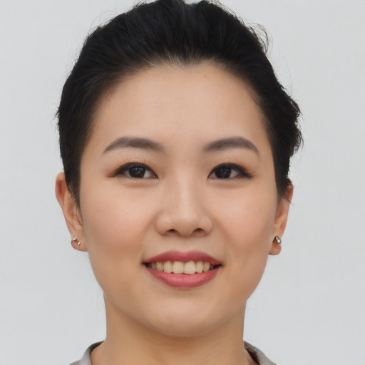 Joyful asian young-adult female with short  brown hair and brown eyes