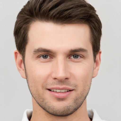 Joyful white young-adult male with short  brown hair and grey eyes