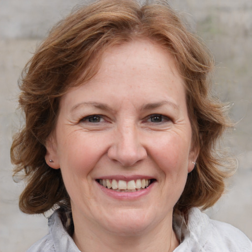 Joyful white adult female with medium  brown hair and blue eyes