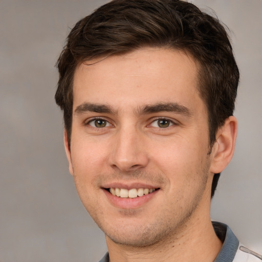 Joyful white young-adult male with short  brown hair and grey eyes