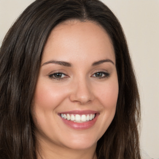 Joyful white young-adult female with long  brown hair and brown eyes