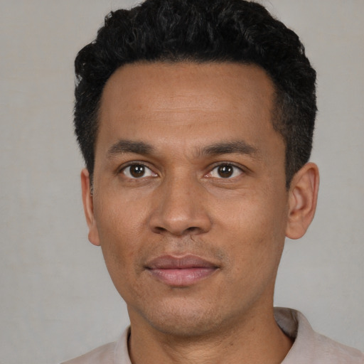 Joyful latino young-adult male with short  black hair and brown eyes