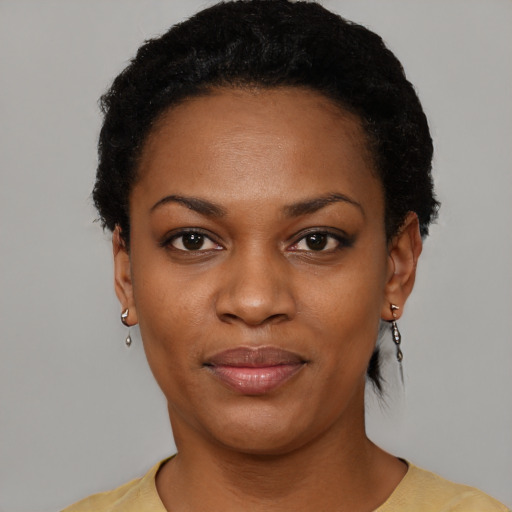 Joyful black young-adult female with short  black hair and brown eyes