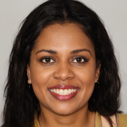 Joyful black young-adult female with long  brown hair and brown eyes