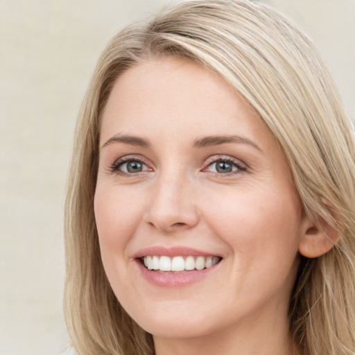 Joyful white young-adult female with long  brown hair and blue eyes