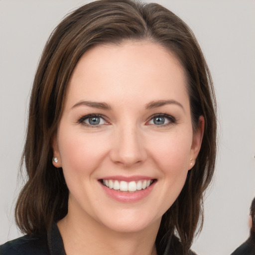 Joyful white young-adult female with long  brown hair and grey eyes