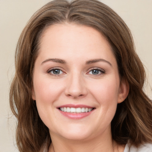 Joyful white young-adult female with long  brown hair and green eyes