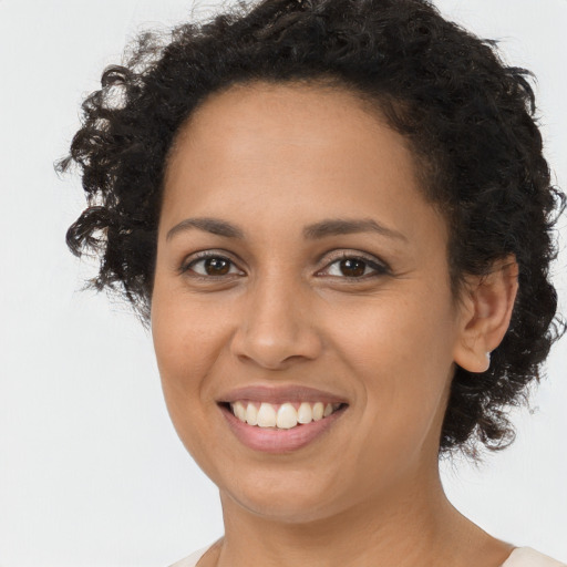 Joyful black young-adult female with long  brown hair and brown eyes