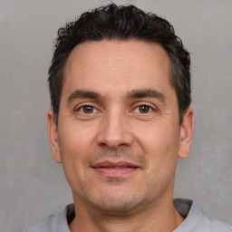 Joyful white adult male with short  black hair and brown eyes