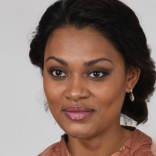 Joyful black young-adult female with long  brown hair and brown eyes