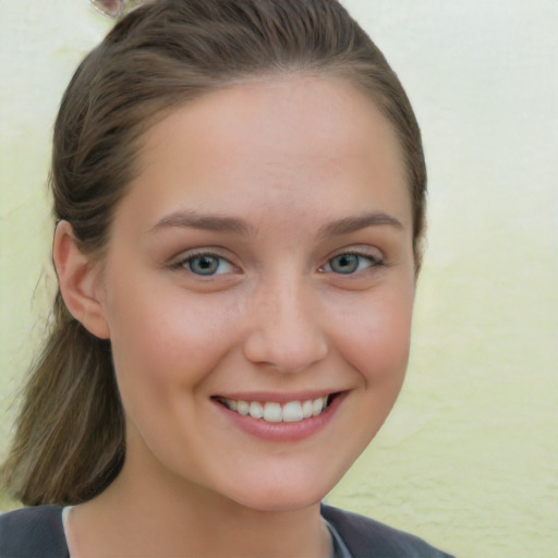 Joyful white young-adult female with long  brown hair and blue eyes